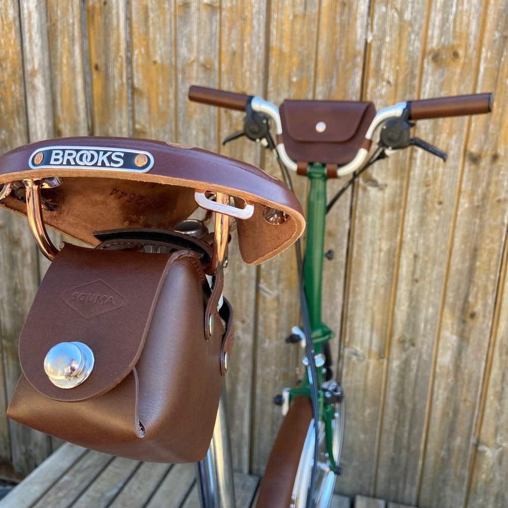 Brown bicycle saddle bag with silver hardware closure close-up 