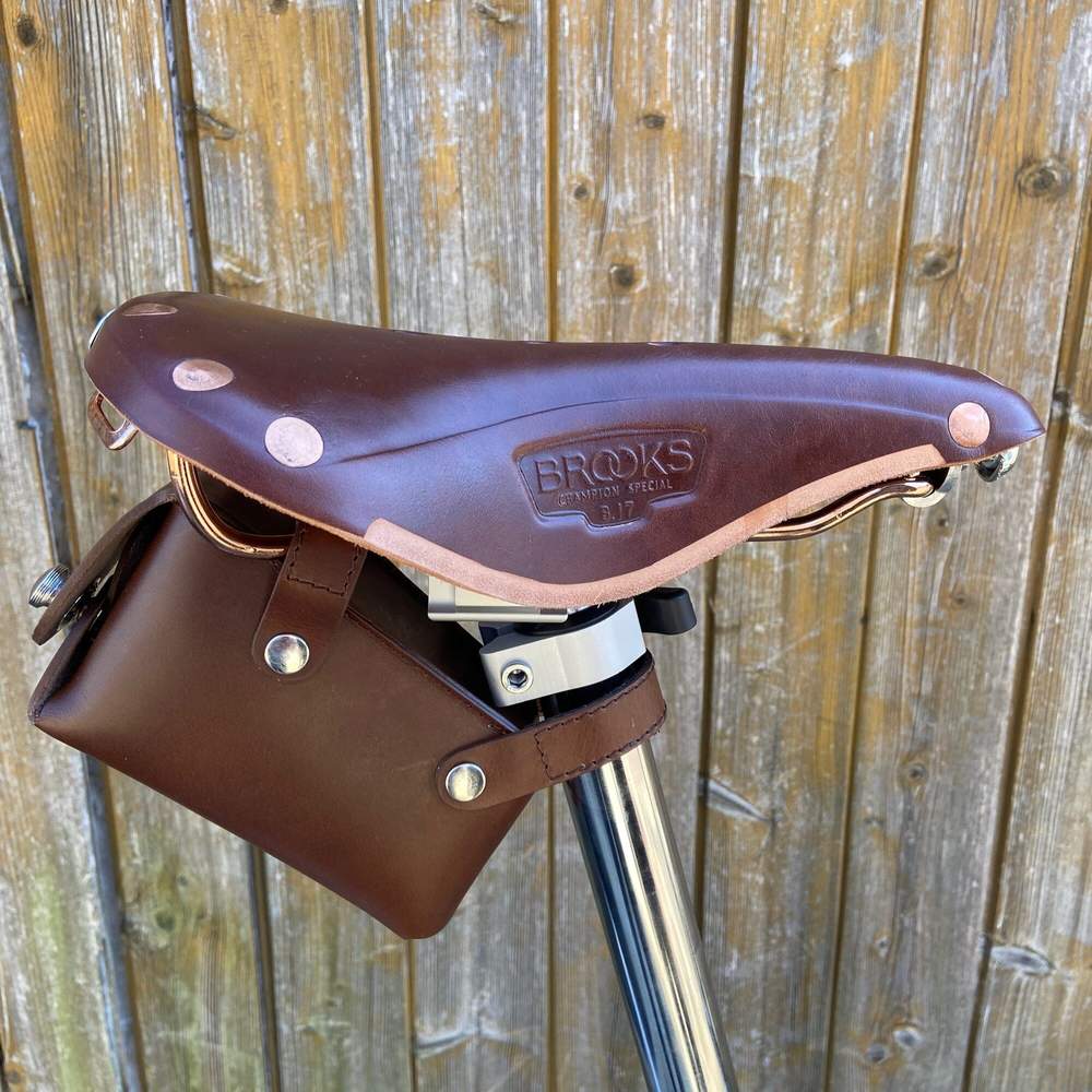 Brown bicycle saddle bag with silver hardware close-up sideview