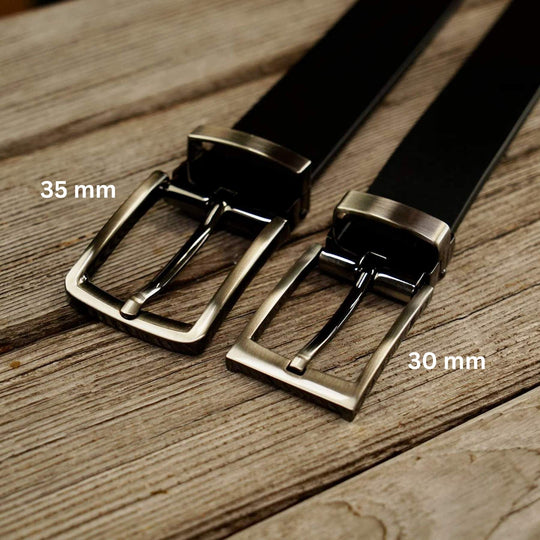 Two black belts with brass buckles on a wooden surface