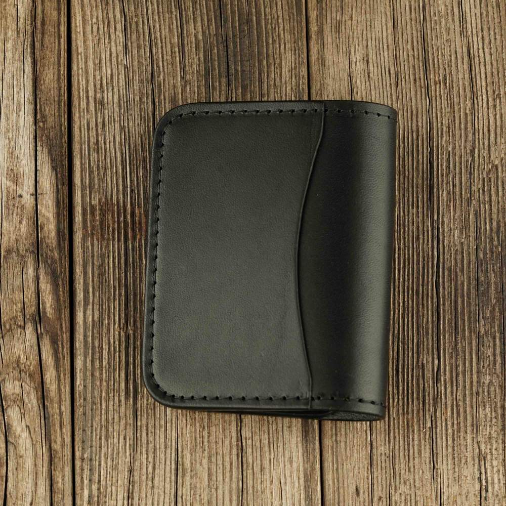 Black leather bifold wallet with slot on Apple AirTag black side view