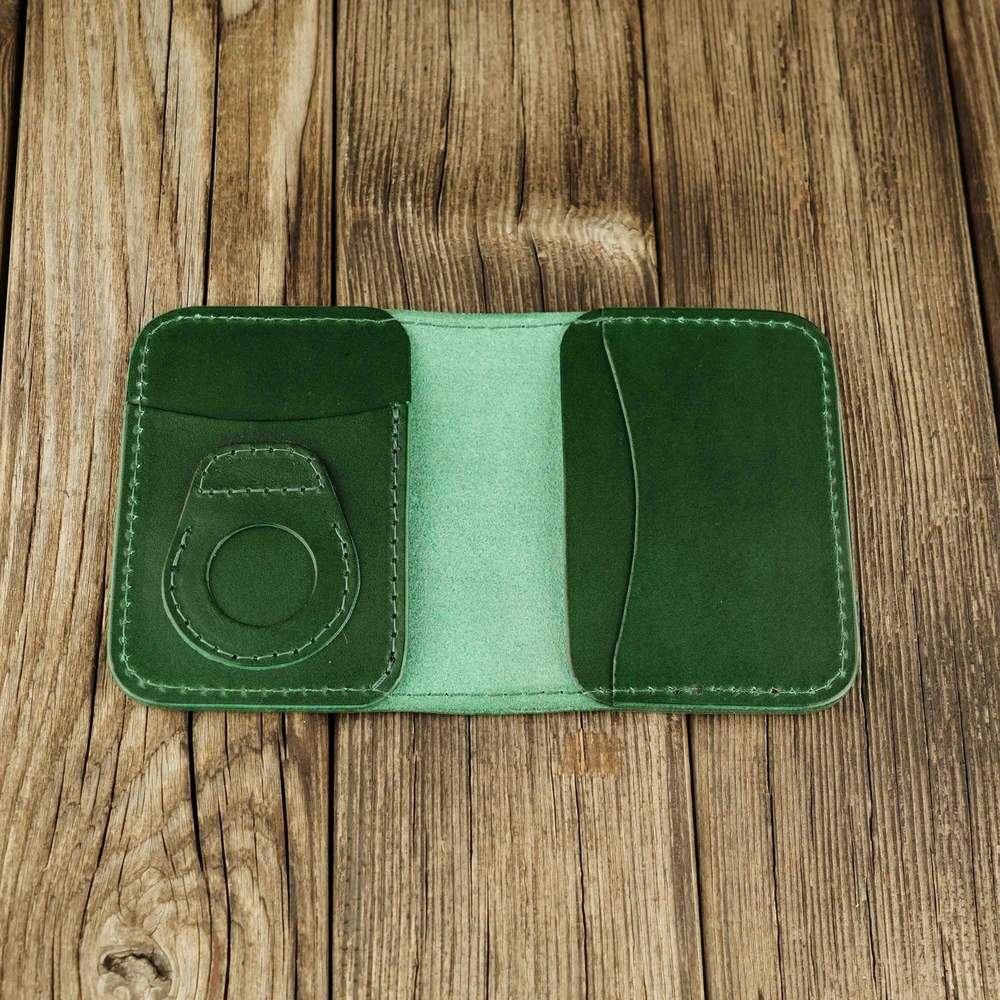 Green leather cardholder with slot on Apple AirTag slot, open