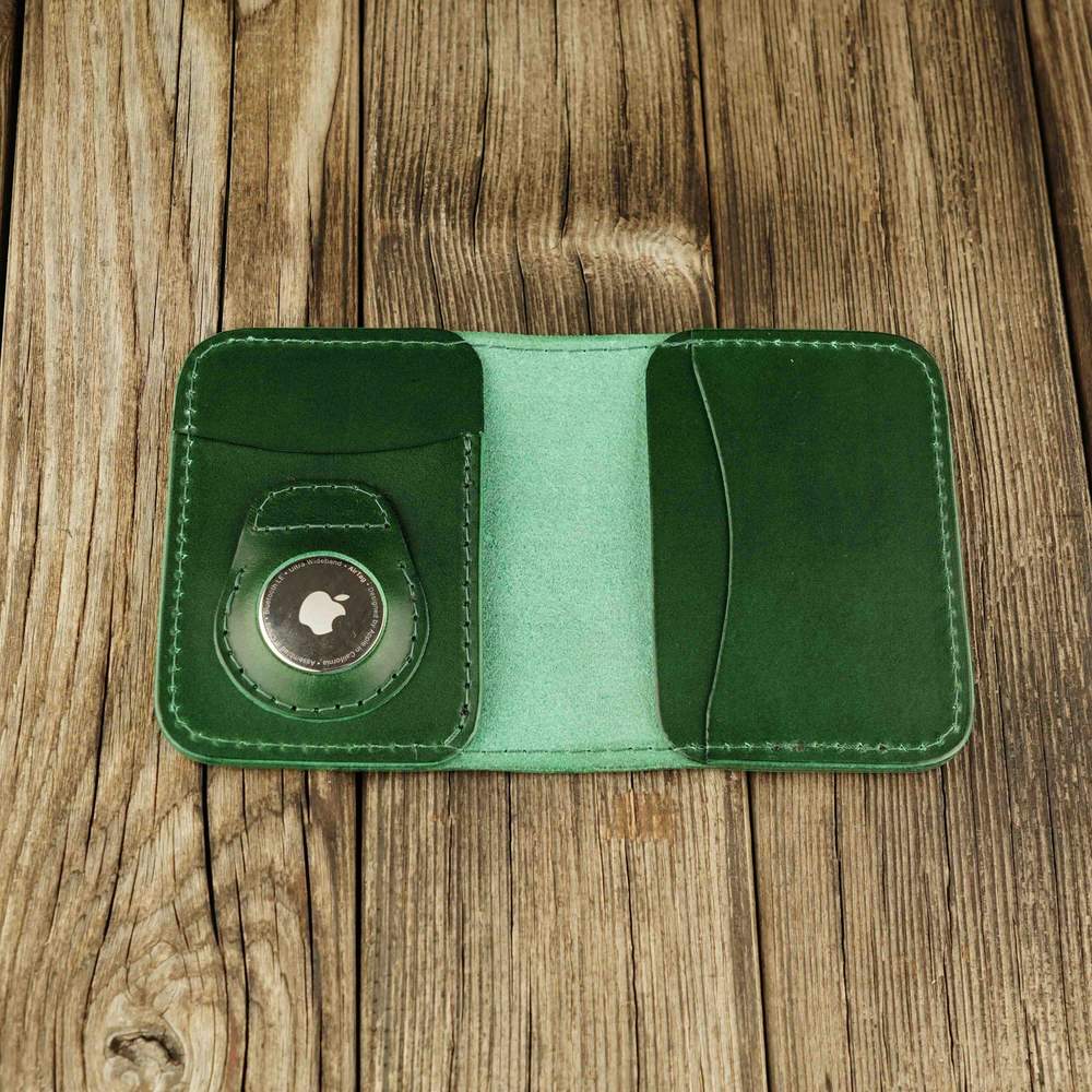 Green leather cardholder with slot on Apple AirTag slot, open