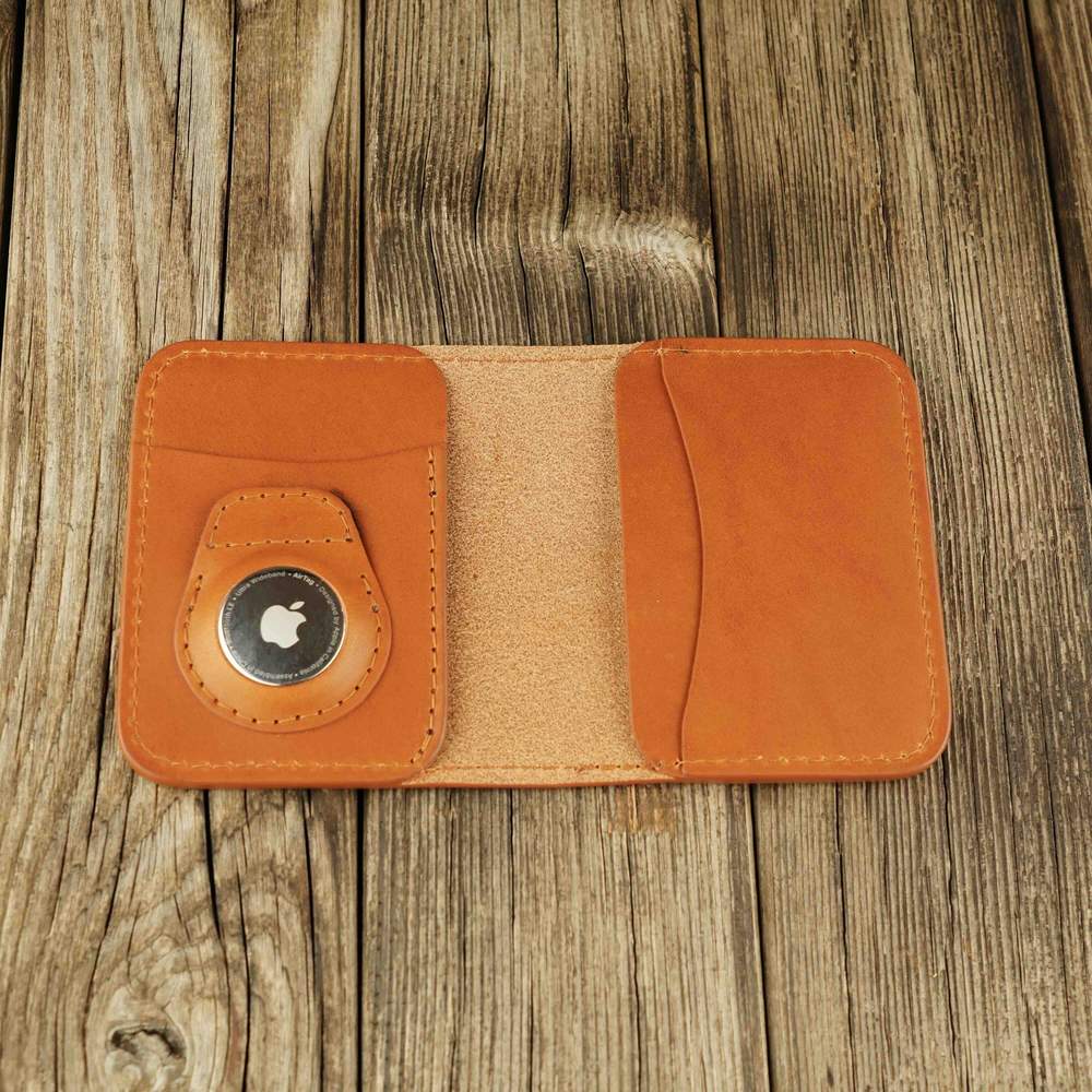 Honey leather Apple Airtag wallet with a logo on a wooden background, open