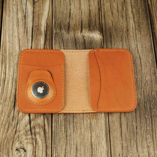 Honey leather Apple Airtag wallet with a logo on a wooden background, open