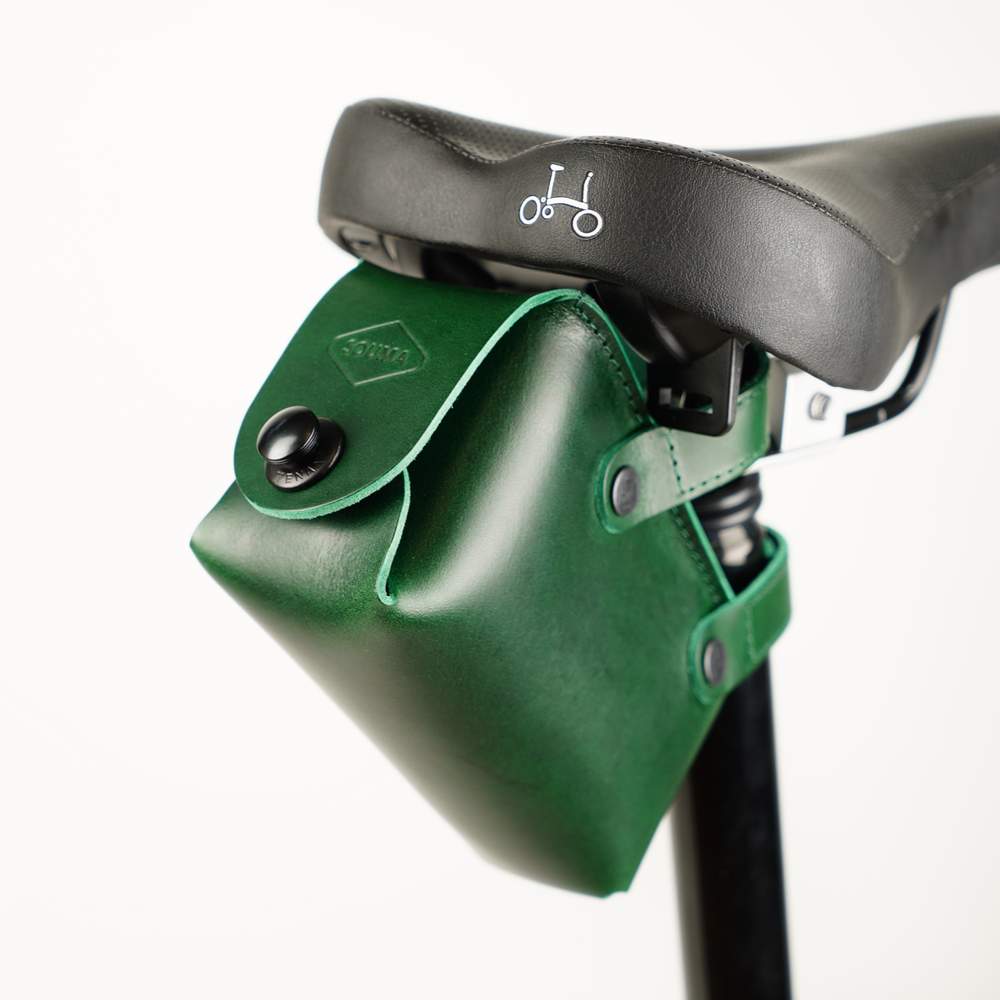 Green bicycle saddle bag with black hardware sideview on white background detail