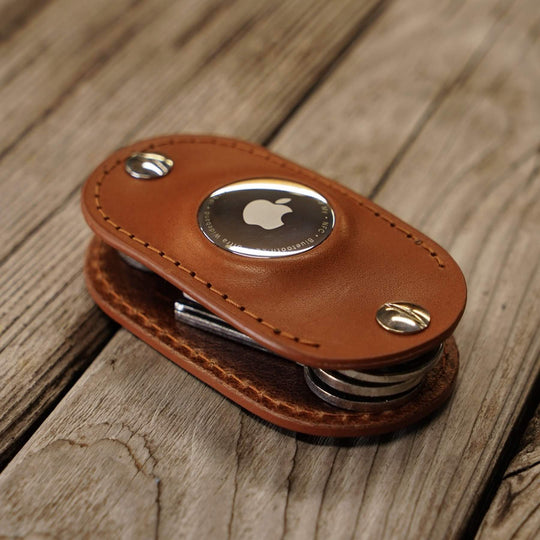 Honey leather key organizer with Apple AirTag slot on a wooden surface