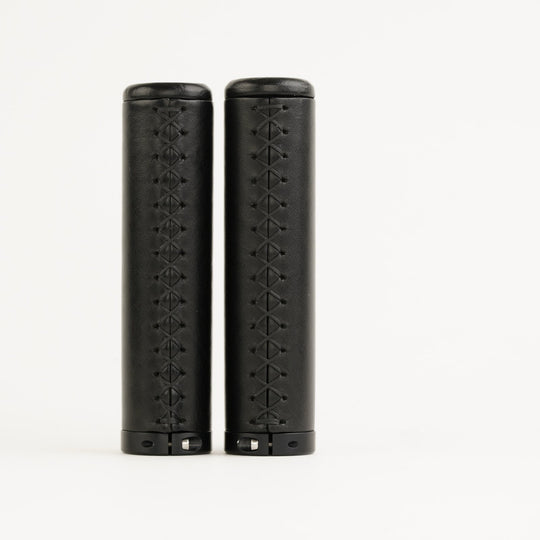 Pair of black bicycle grips with stitching on white background